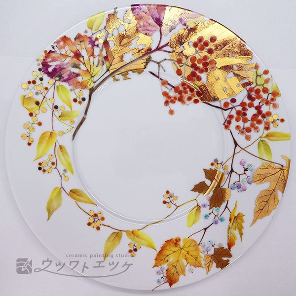 色づいた葉や実が絵具や金で描かれた丸皿