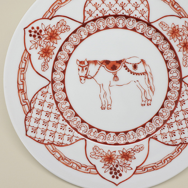 赤絵で馬やチェーンや蹄鉄などが描かれたお皿の一部分