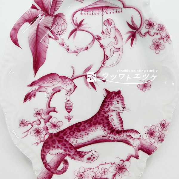 ワインレッドで動物と植物が描かれた菱形レリーフ皿の部分拡大