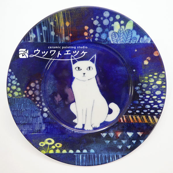 紺地にカラフルな線描きイラストの背景と猫が描かれた丸皿