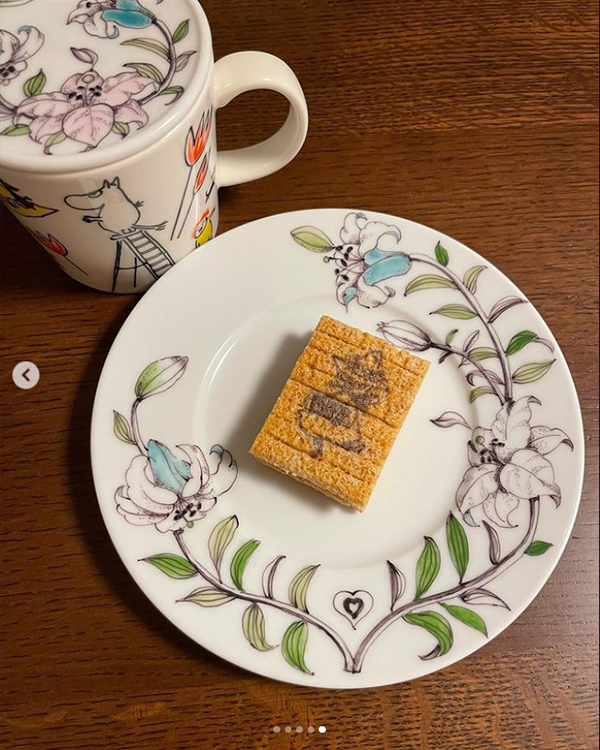 お菓子の乗ったユリが描かれた丸皿とマグカバー