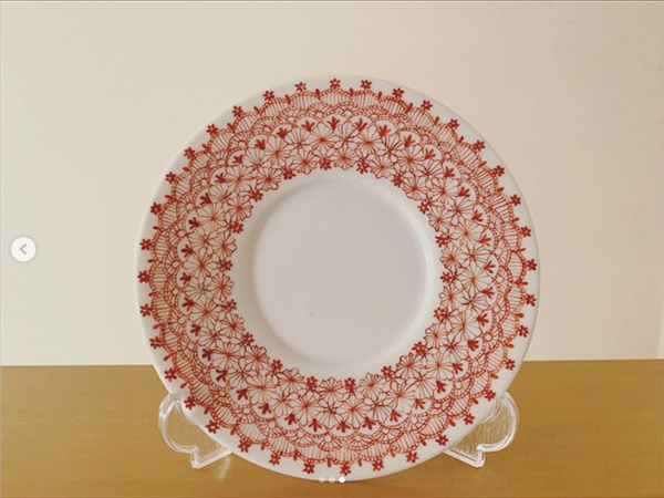 赤でレース文様が描かれた丸皿