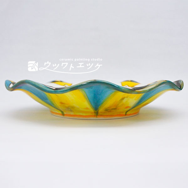 釉薬や下絵具でオズの魔法使いの登場人物が描かれた波型皿の側面