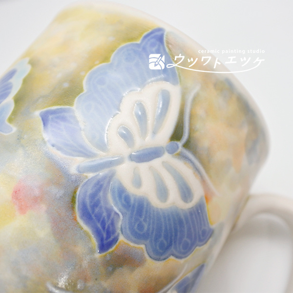 釉薬や下絵具で蝶が描かれたマグ