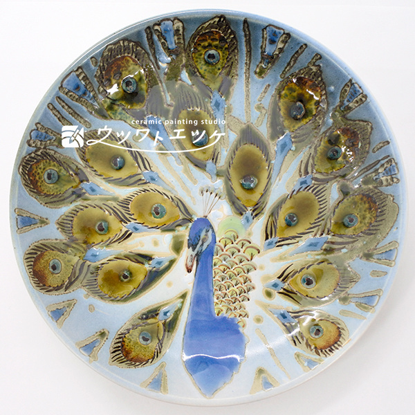 釉薬や下絵具で正面を向いたクジャクが描かれたお皿
