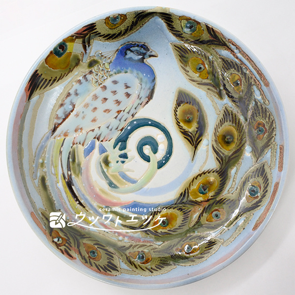 釉薬や下絵具で横を向いたクジャクが描かれたお皿