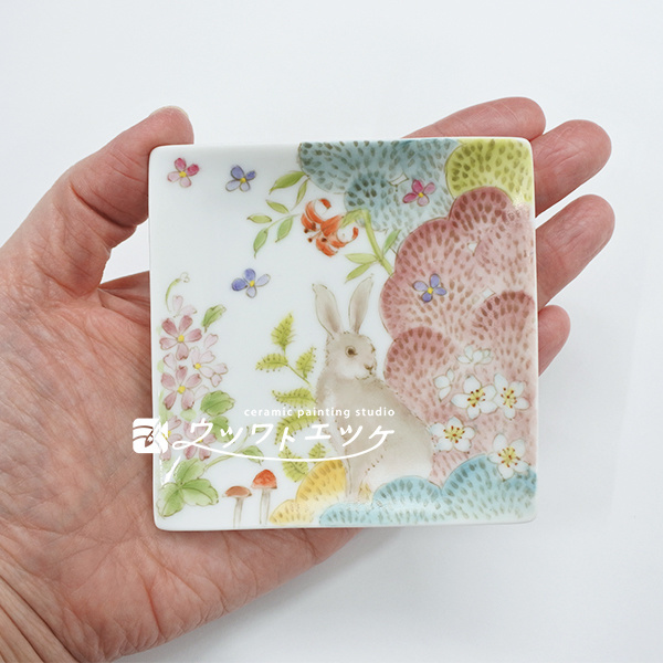 森にいるウサギが描かれた小皿を手のひらに乗せている状態