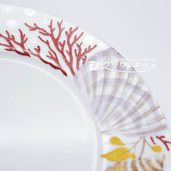 ラスターや絵具で貝やサンゴが描かれた丸皿の拡大