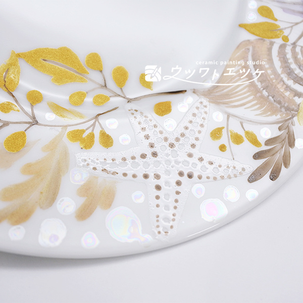 ラスターや絵具で貝やヒトデが描かれた丸皿の拡大