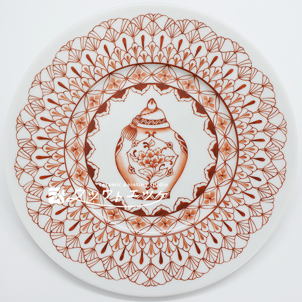 繊細な赤絵文様の真ん中に中国風の壺が描かれた丸皿