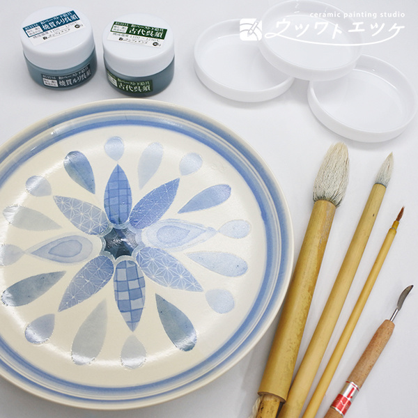 染付で模様が描かれた丸皿と使用する筆や絵具の集合