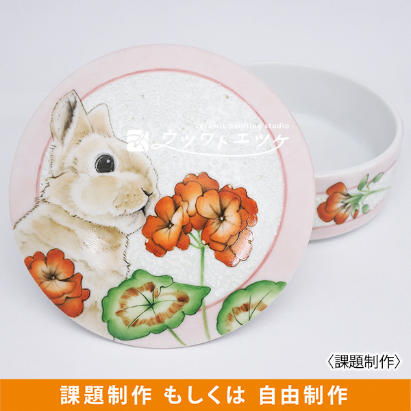 ウサギと赤いゼラニウムが描かれた円形小箱の蓋が開いた状態