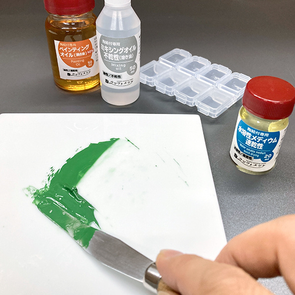 タイルの上でパレットナイフを使い緑色の絵具を練っているところ