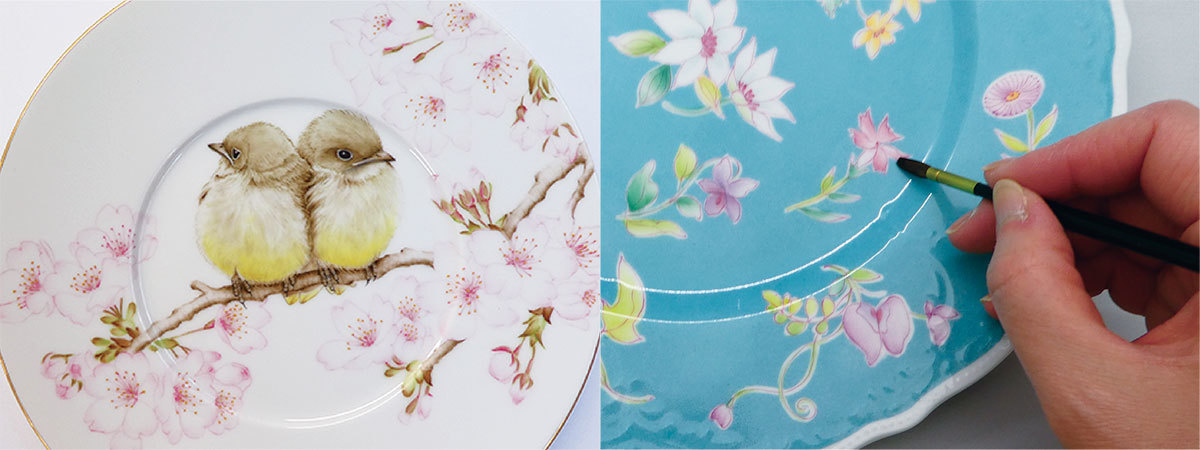 桜にとまる鳥が描かれたお皿と青いお皿に花を描いている手元